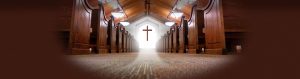 wooden church pews and light shining behind cross