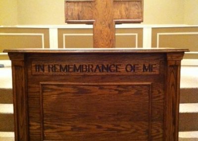 wooden cross pulpit and "in remembrance of me" table
