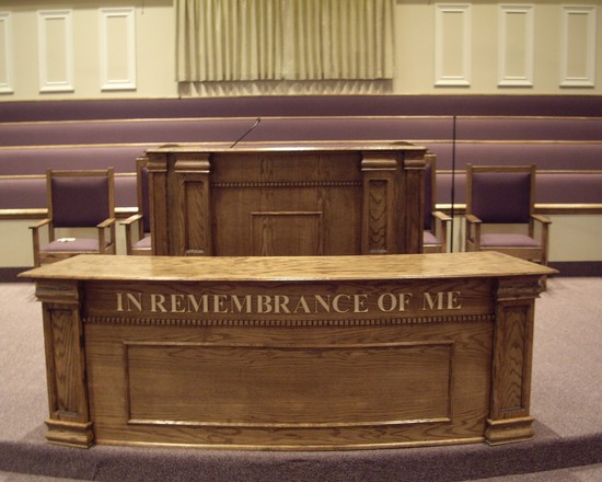 wooden pulpit and "in remembrance of me" table